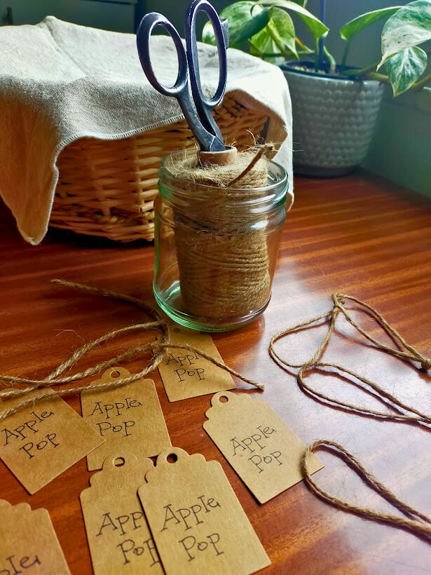 Twine with scissors inside sitting on a table with homemade tags