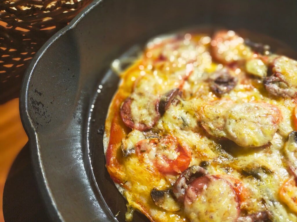 Cooked gluten free pizza in a cast-iron skillet ready to serve.