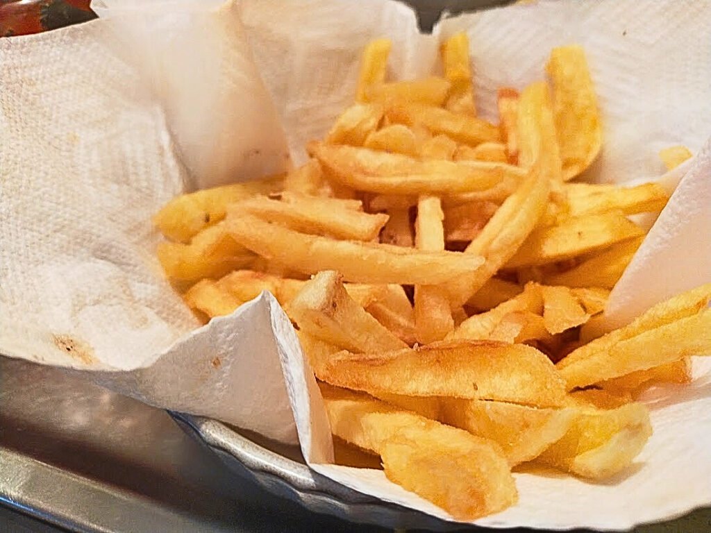 Bowl of homemade fries sitting on paper towel in a bowl