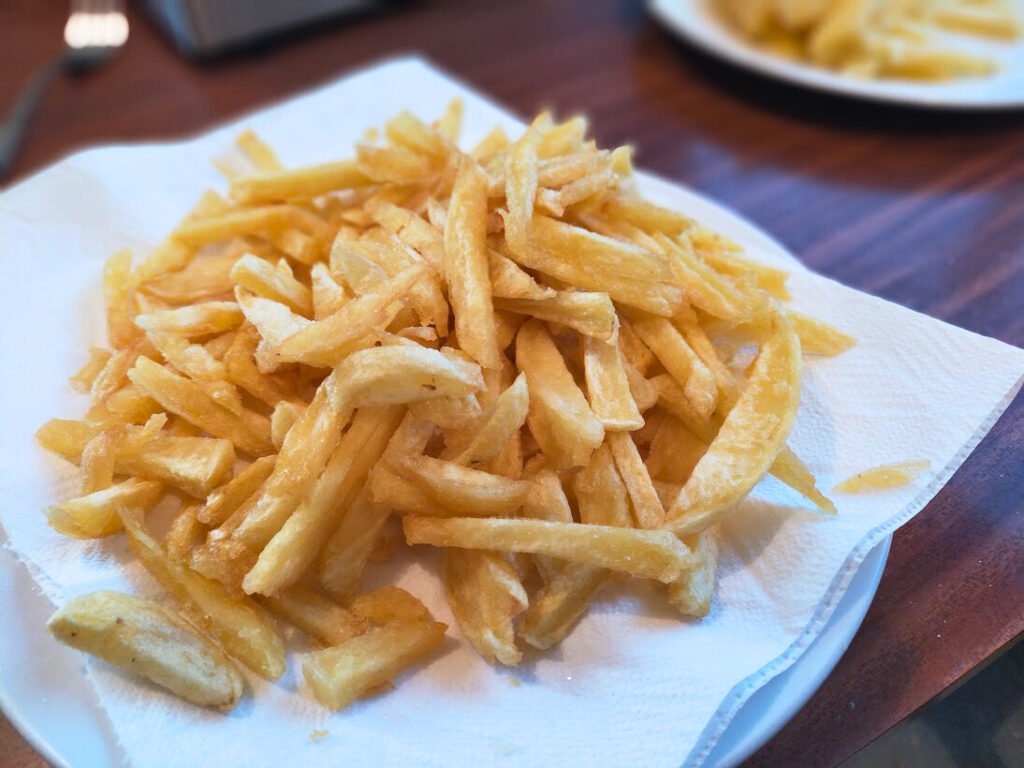 Cooked homemade fries from scratch sitting on a plate.