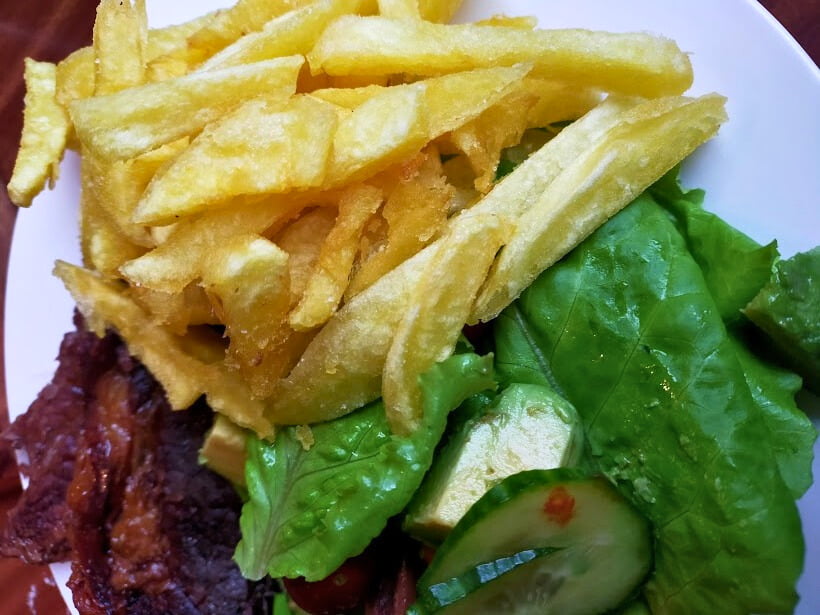 Homemade fries served on a plate with lettuce and cucumber.