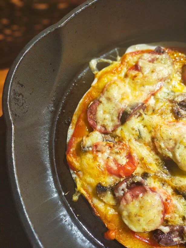 Cooked gluten free pizza in a cast-iron skillet ready to serve