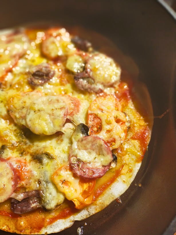 cooked gluten free pizza in a cast-iron skillet