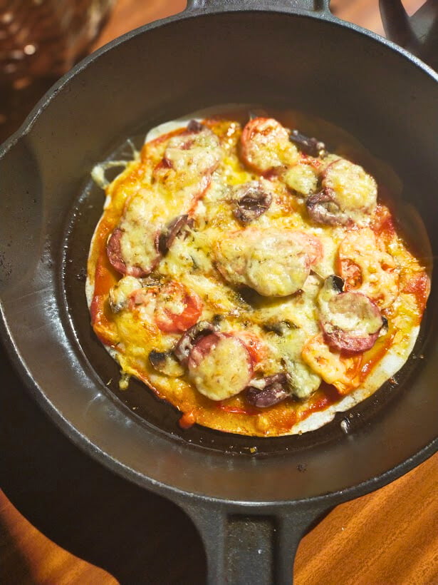 Cooked gluten free pizza in a cast-iron skillet