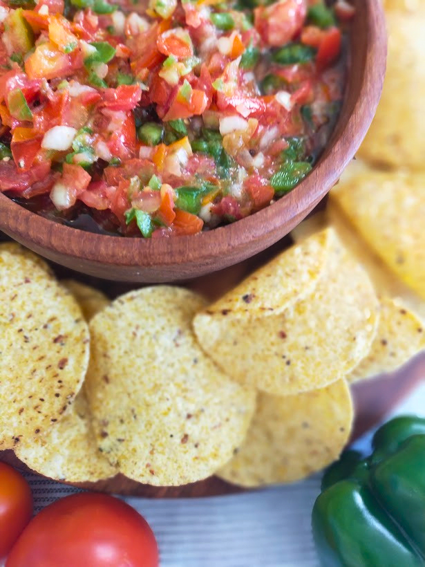 Tomato salsa in a wooden bowl served with cornchips