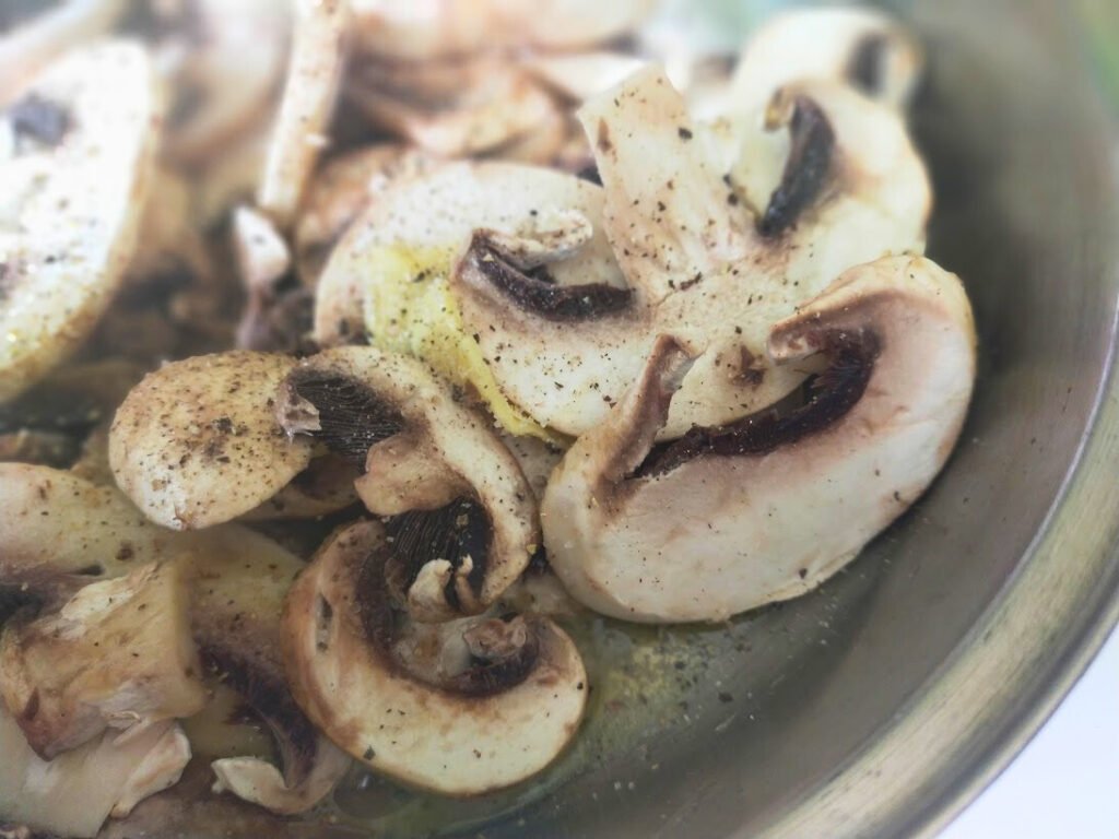 Cooking sliced mushrooms in butter to make creamy mushroom sauce