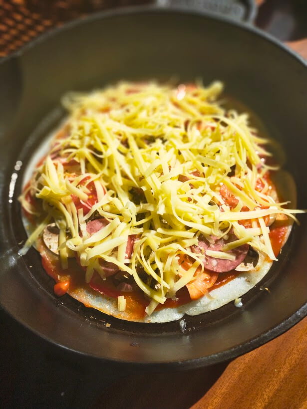 Uncooked pizza in a cast-iron skillet