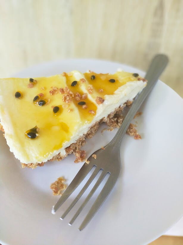 Passionfruit syrup served on cheesecake with a fork.