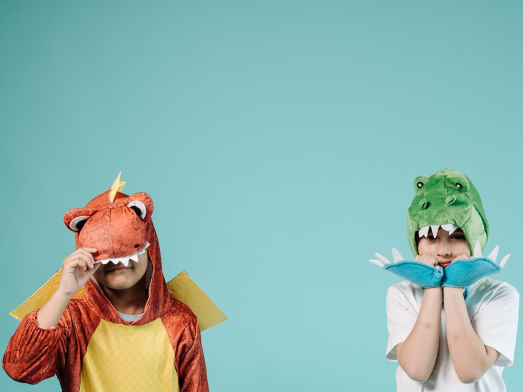 Two children in dress up costumes keeping themselves busy with a screen free activity.