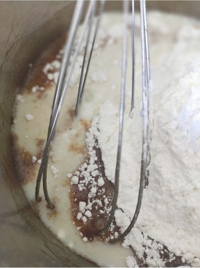 whisking the gingerbread loaf ingredients together in a pot