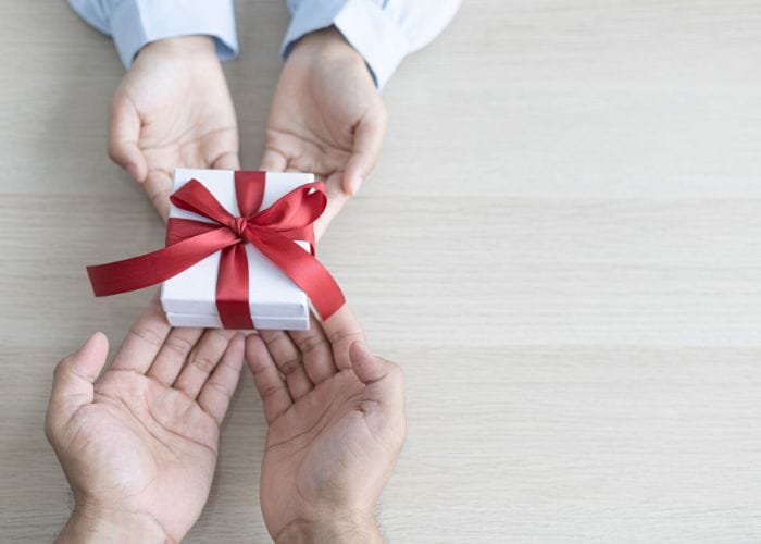 Hands of a child gift giving to the hands of an adult