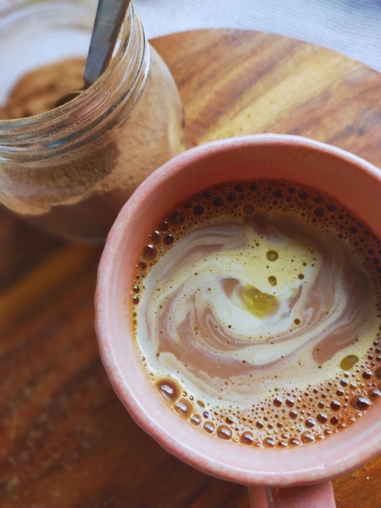 creamy milk added to pink mug for hot drink